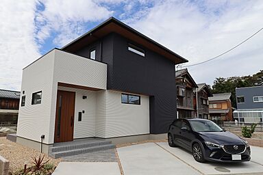 ユニバーサルホーム津店 【ユニバーサルホーム加盟法人上棟ランキング25年連続1位】の施工事例「【2階建て/4LDK】折り上げ天井×白黒外観、テラスとつながるリビングの家」の画像